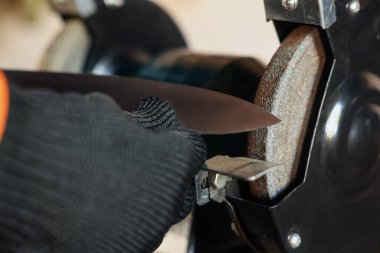 Bıçak keskinleştiren adam içeride, yakın plan.