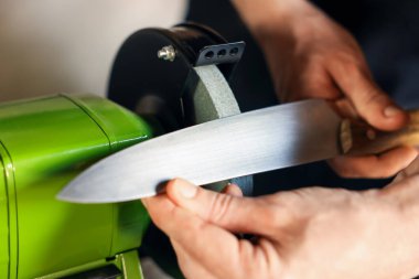 Bıçak keskinleştiren adam içeride, yakın plan.