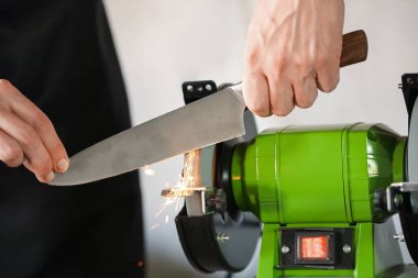 Bıçak keskinleştiren adam içeride, yakın plan.