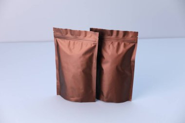 Açık gri arka planda iki fermuarlı stand-up kesesi. Tasarım için model