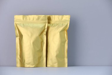 Açık gri arka planda iki fermuarlı stand-up kesesi. Tasarım için model