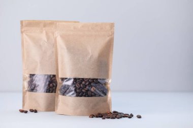 Açık gri arka planda kahve çekirdekli fermuar stand-up torbaları. Tasarım için model