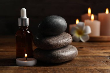 Düşüren, taşlar ve yanan mumlarla kaplıca bileşimi siyah arkaplanda, yakın plan