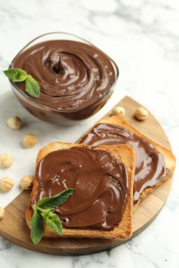 Çikolata, naneli ve fındıklı beyaz mermer masa, yakın plan.