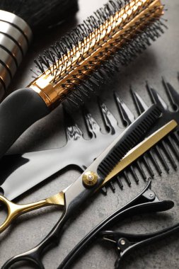 Gri masadaki farklı kuaför aletleri, yakın plan.