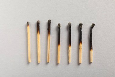 Gri arkaplanda yanmış kibritler, düz yatış