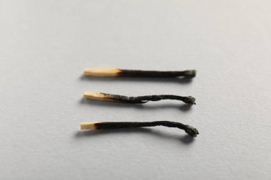 Gri arkaplanda yanmış kibritler, yakın plan görünümü