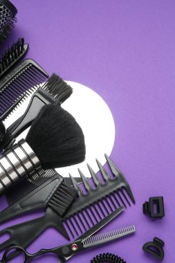 Mor arka planda farklı kuaför aletleri, düz yatış