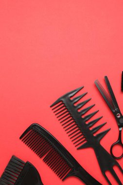 Kırmızı arka planda farklı kuaför aletleri var. Metin için boşluk