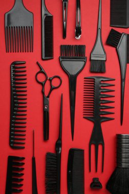 Kırmızı arka planda farklı kuaför aletleri, düz yatıyordu