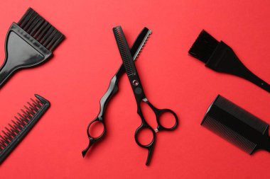Kırmızı arka planda farklı kuaför aletleri, düz yatıyordu