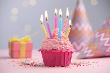 Kekin içinde mum yakmak, fıskiyeler ve bulanık ışıklara karşı parti dekorasyonu.