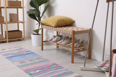 Koridordaki raflarda farklı ayakkabılar var.