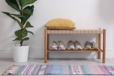 Koridordaki raflarda farklı ayakkabılar var.