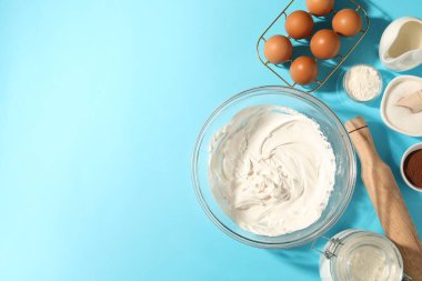 Krem şanti kasede ve diğer ürünler açık mavi masada, düz yerde. Metin için boşluk