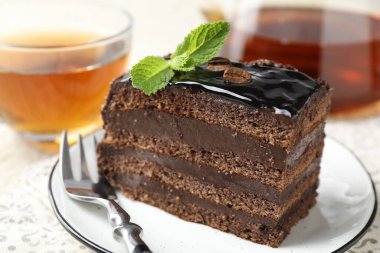 Nane, çatal ve çayla servis edilen çikolatalı kek.