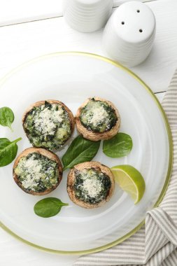 Beyaz ahşap masada servis edilen lezzetli mantarlar.