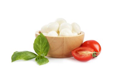 Beyaz arka planda lezzetli mozzarella peynir topları, domates ve fesleğen.