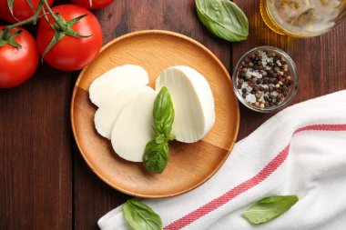 Lezzetli mozzarella, domates ve fesleğen, ahşap masa, düz uzanma