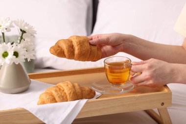 Kadın yatakta nefis bir kahvaltı yapıyor, yakın plan.