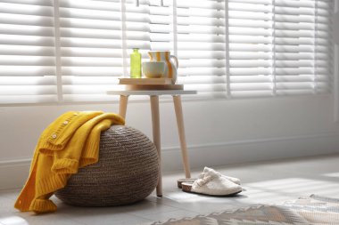 Evde şık örülmüş bir puf ve süveter. Metin için boşluk