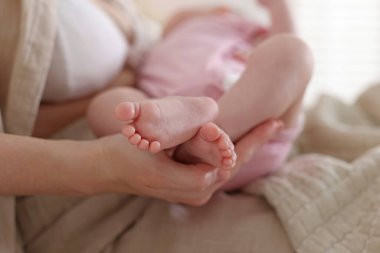 Anne evde yeni doğmuş bebeğiyle, yakın plan.