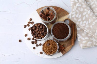 Farklı türde hazır kahve, fasulye ve baharatlar açık dokulu masa, üst görünüm