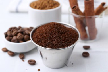 Anında kahve tozu, fasulye ve tarçın çubukları ışık masasında, yakın plan.