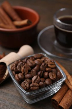 Kavrulmuş fasulye, kepçe ve tarçın çubukları ahşap masada, yakın plan.