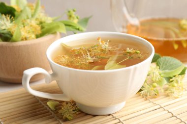 Taze ıhlamur çayı, çaydanlık ve çiçekler masada, yakın plan.