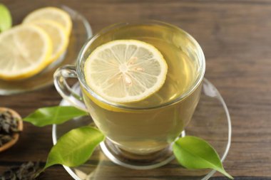 Limonlu yeşil çay ve ahşap masa yaprakları, yakın çekim