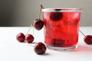 Buzlu vişneli gazoz ve beyaz ahşap masada böğürtlen.