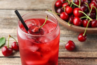 Buzlu vişneli gazoz ve ahşap masada böğürtlen.