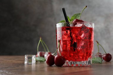 Buzlu vişneli gazoz, böğürtlen ve nane şekerli ahşap masa, yakın plan. Metin için boşluk