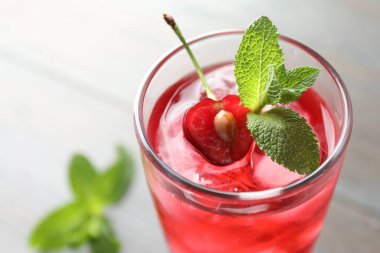 Buzlu vişneli soda, dutlu ve naneli cam ışıklı masa, yakın plan.