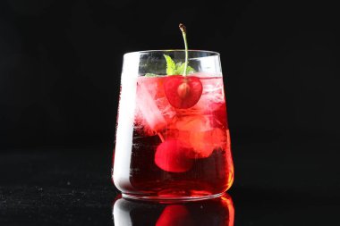 Buzlu vişneli soda, aynalı masada buzlu nane ve nane şekeri, siyah arka planda, yakın planda.