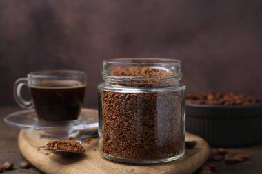 Cam kavanozdaki anlık kahve, masada sıcak içecek ve fasulye, yakın plan.