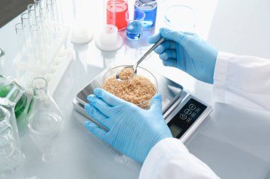 Petri kabını tartan bilimadamı beyaz ayna masasında, yakın plan.