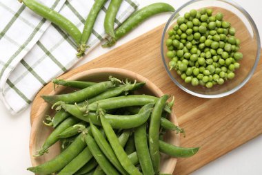 Taze taze bezelyeler beyaz ahşap masada, düz yatıyordu.