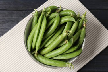 Taze taze bezelyeler, siyah ahşap masa, üst manzara.