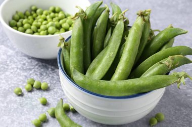 Gri masada taze taze taze bezelyeler, yakın plan.