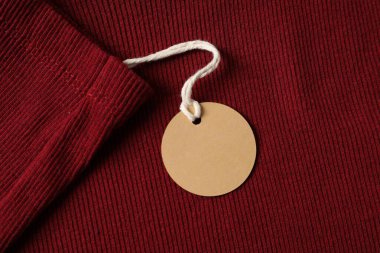 Kırmızı giysinin üzerindeki karton etiket, üst görünüm