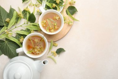 Taze ıhlamur çayı, çaydanlık ve çiçekler beyaz masada, düz yerde. Metin için boşluk