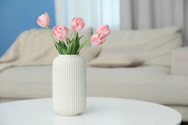 Beyaz masadaki vazodaki güzel lale çiçekleri, metin için yer.