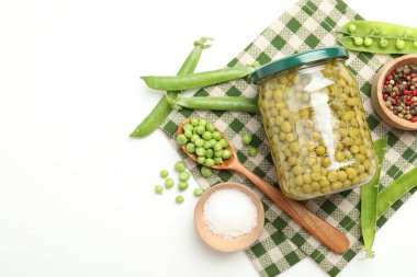 Kavanozda bezelye turşusu ve beyaz masada malzemeler. Metin için boşluk