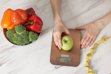 Kadın mutfak terazisinde ağırlıklı beyaz mermer masa, üst manzara