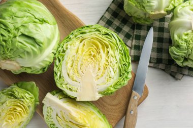 Taze taze lahana ve açık ahşap masa üzerinde kesilmiş lahanalar.