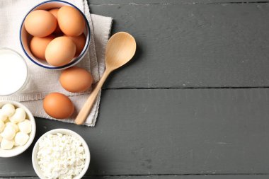 Gri ahşap masa üzerinde farklı süt ürünleri ve yumurtalar, düz yatak. Metin için boşluk