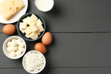 Gri ahşap masa üzerinde farklı süt ürünleri ve yumurtalar, düz yatak. Metin için boşluk