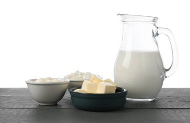 Gri ahşap masada beyaz arka planda farklı süt ürünleri